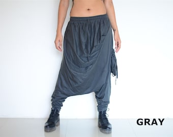 May include: Gray, loose-fitting pants with a gathered design and a side pocket. The pants are made of a soft, comfortable fabric.