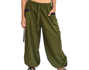 May include: Olive green loose-fitting pants with a black waistband and side pockets. The pants have a drawstring waist and a relaxed fit.