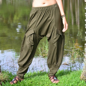 May include: A pair of olive green, loose-fitting trousers with cargo pockets. The trousers are made of a soft, comfortable fabric and have a relaxed fit.