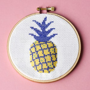 May include: A yellow and blue pineapple cross-stitch embroidery in a wooden hoop.