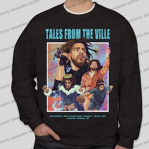 Könnte beinhalten: Schwarzer Pullover mit einem Grafikdruck eines Mannes mit einem Mikrofon und dem Text "Tales From The Ville". Die Grafik enthält auch andere Figuren und einen Basketball. Der Text "The Original I. Cole Graphic Novel / Volume 1 / March, 2021" ist unten auf der Grafik gedruckt.