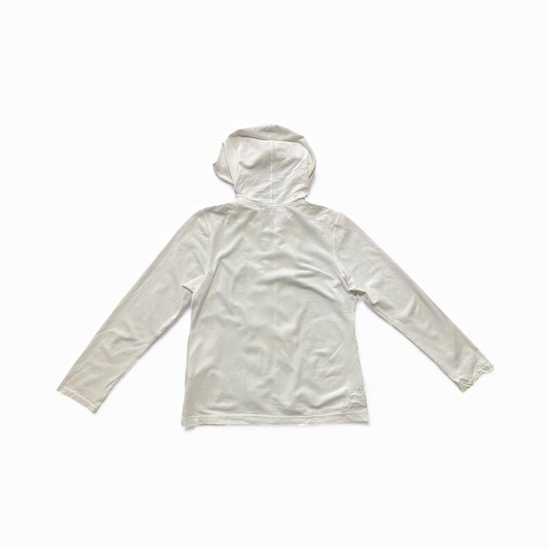 May include: A white long-sleeved hoodie, viewed from the back, with a hood and a relaxed fit. The garment is made of a soft, lightweight material, perfect for layering or casual wear. The sleeves are long and extend to the wrists.