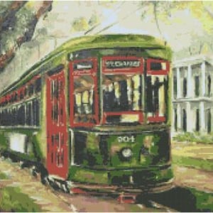 May include: A green and red vintage streetcar with the word "VOUCANES" on the side. The streetcar is on a street with a white building in the background.
