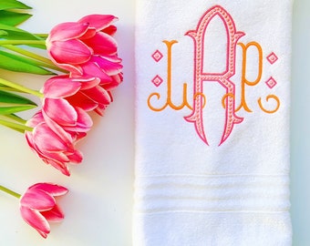 May include: White bath towel with a pink and orange embroidered monogram "LRP" in a script font.