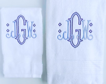 May include: Two white towels with blue and purple embroidered initials "JGW" in a decorative font.