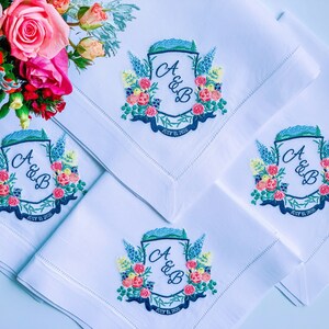 May include: Four white linen napkins with embroidered floral designs and the initials "A & B" and the date "July 12, 2020".