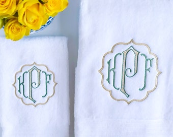 May include: Two white towels with green and gold embroidered monograms. The monogram is "KPF" in a decorative script font.