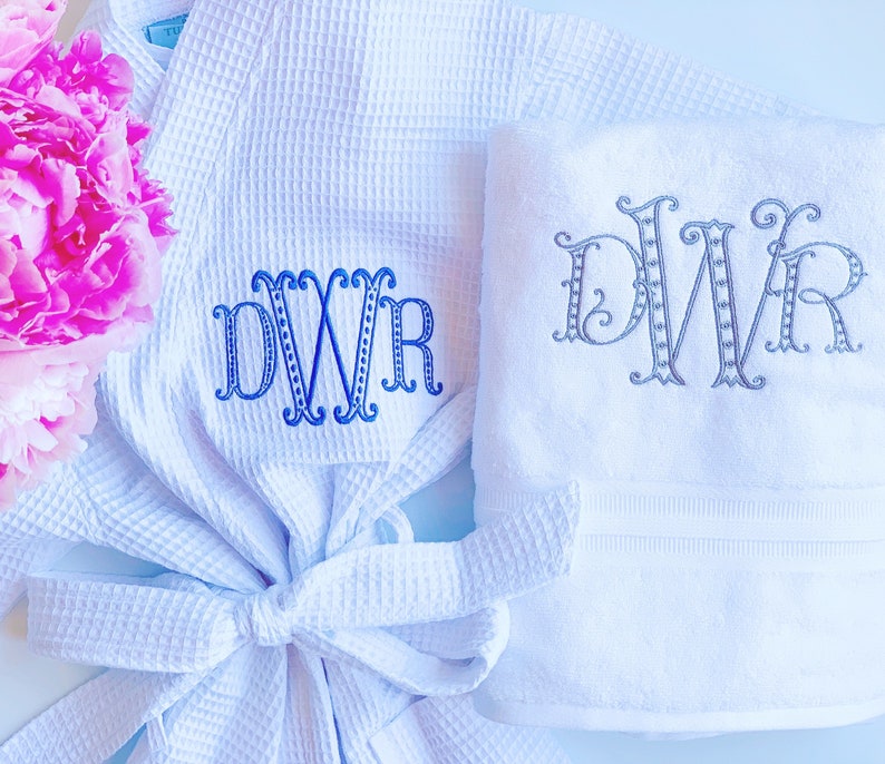 May include: A white waffle weave robe and a white towel, both with the monogram "DWR" embroidered in blue thread.