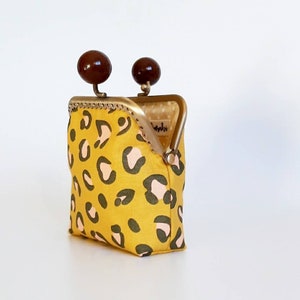 Pequeño monedero de tela animal print color mostaza con cierre de bolas chocolate, cartera de mujer en tela de leopardo con boquilla dorada