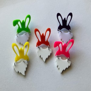 May include: Five colorful bunny ear headbands with white beard accents. The headbands are in green, orange, yellow, pink, and purple.