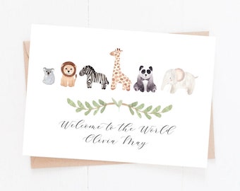 May include: A white card with watercolor illustrations of a koala, lion, zebra, giraffe, panda, and elephant. The text "Welcome to the World Olivia May" is written in elegant script below a green leaf garland.
