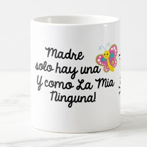 May include: White ceramic mug with black script text that reads "Madre solo hay una y como La Mia Ninguna!" A colorful butterfly graphic with pink, yellow, and blue accents is on the right side of the mug.