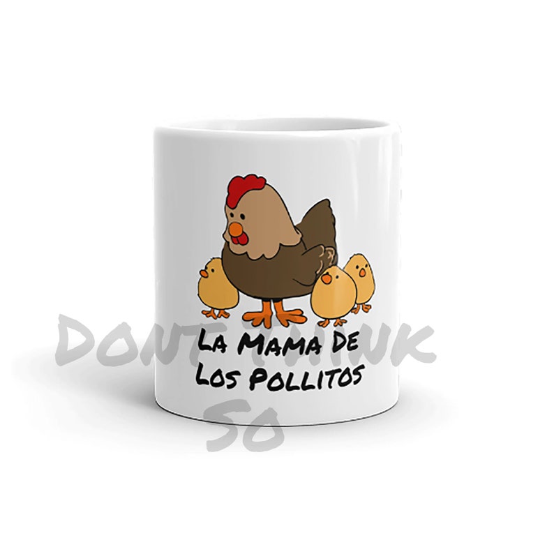May include: White ceramic mug with a cartoon illustration of a hen and three chicks. The hen is brown with a red comb, and the chicks are yellow. The mug has the text "LA MAMA DE LOS POLLITOS".