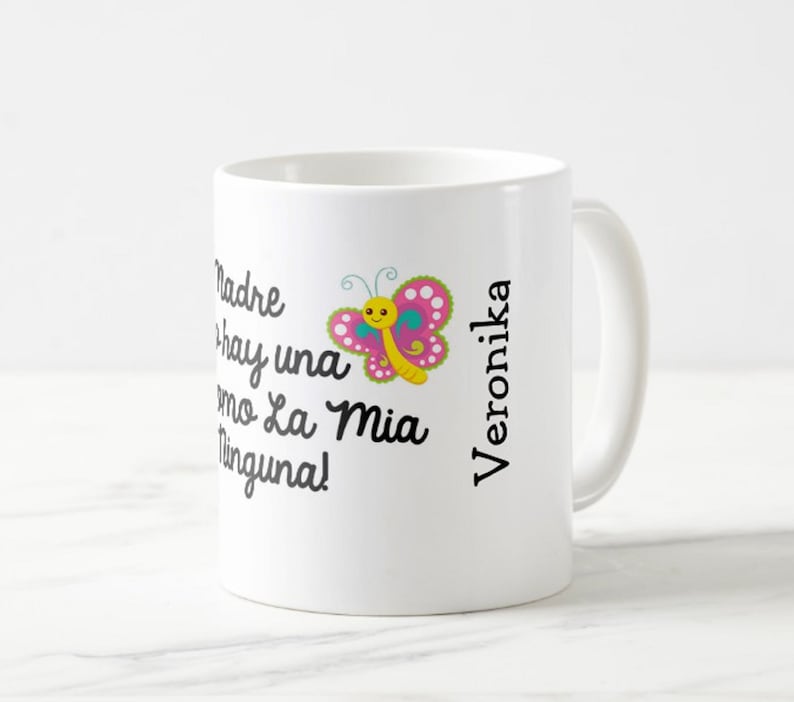 May include: White ceramic mug featuring a colorful butterfly design and the name "Veronika" in black. The mug has text in Spanish. A perfect gift for a loved one.