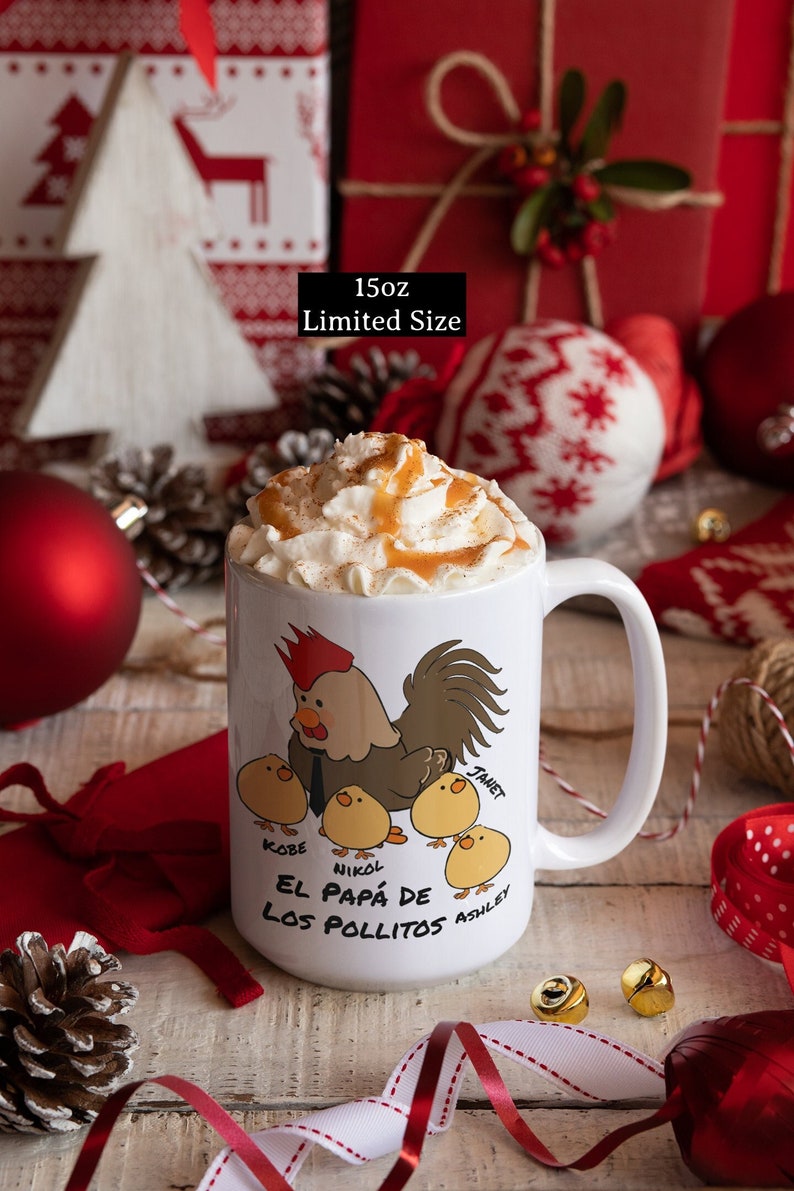 May include: A white ceramic mug with a cartoon rooster and chick design, filled with whipped cream and caramel drizzle. The mug has the text "El Pap&aacute; de Los Pollitos" and names. The mug is 15oz.