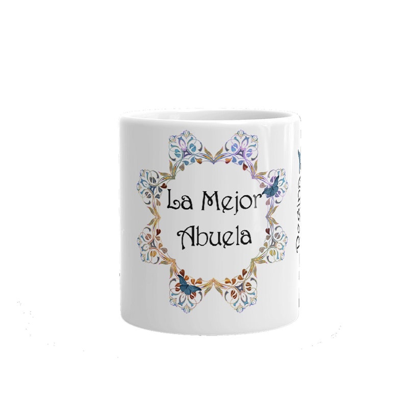 May include: White ceramic mug with a decorative floral design in blue, gold, and purple. The mug features the text "La Mejor Abuela" in black script, surrounded by a floral wreath. A perfect gift for a grandmother.