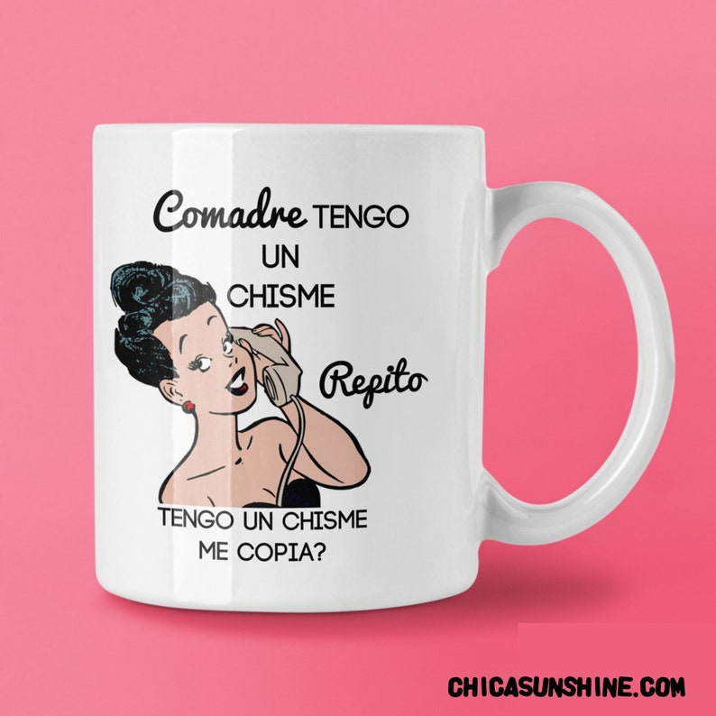 Pu&ograve; includere: Tazza in ceramica bianca con un'illustrazione retr&ograve; di una donna al telefono e il testo spagnolo "Comadre TENGO UN CHISME Repito TENGO UN CHISME ME COPIA?" in nero. La tazza ha un manico curvo e il sito web CHICASUNSHINE.COM.