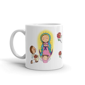 May include: White ceramic mug featuring a colorful illustration of a religious figure with a halo, a child, and a kneeling figure offering flowers. Red roses are scattered around the design. The mug has a white handle.