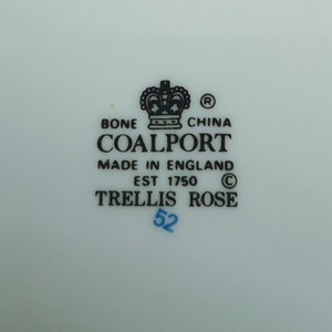May include: A white porcelain plate with a black and white Coalport Trellis Rose china mark. The mark includes a crown, the words "Bone China", "Coalport", "Made in England", "Est 1750", and "Trellis Rose". The number "52" is written in blue ink.