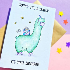 Puede incluir: Una tarjeta de cumplea&ntilde;os con una llama verde que lleva un gorro de fiesta y lleva un regalo. La tarjeta dice "Sound the A-llama! It's your birthday!"
