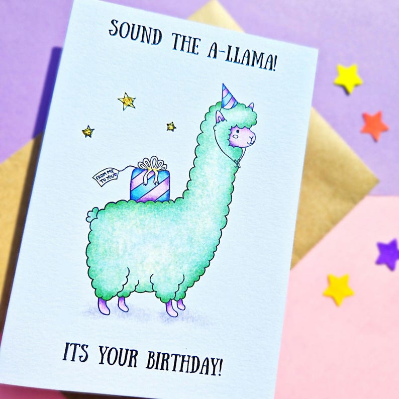 Puede incluir: Una tarjeta de cumplea&ntilde;os con una llama verde que lleva un gorro de fiesta y lleva un regalo. La tarjeta dice "Sound the A-llama! It's your birthday!"