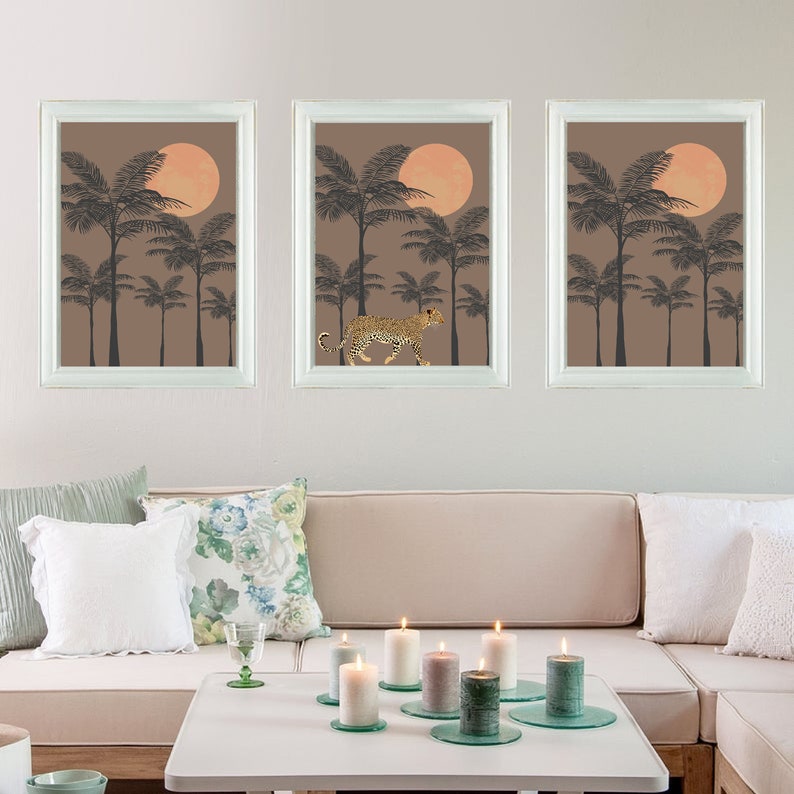 May include: Three framed prints with a brown background and a large orange circle in the center. The prints feature silhouettes of palm trees and a leopard walking through the center print.