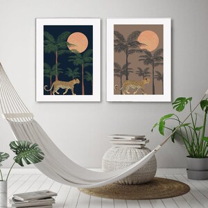 May include: Two framed prints with a jungle scene. Each print features a leopard walking through a palm tree forest under a large, orange moon. One print has a dark blue background and the other has a light brown background.