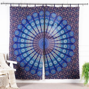 May include: A pair of blue and white mandala patterned curtains with a floral design. The curtains are made of cotton and are perfect for adding a touch of bohemian style to any room.