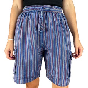 May include: Blue, purple, and white striped shorts with a drawstring waist and cargo pockets. The shorts are made of a lightweight fabric and have a relaxed fit. The vertical stripes create a visually appealing pattern.