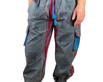 Puede incluir: Pantalones cargo grises con cintura con cordón, con diseños de sol y paisley negros. Los pantalones tienen rayas rojas y blancas en los laterales, detalles de bolsillo azules y puños estampados. Fabricados con un material suave y cómodo.