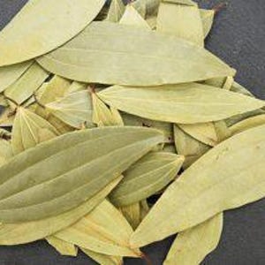 May include: A pile of dried bay leaves, showcasing a light green color and distinct veining. The leaves are oval-shaped and appear to be freshly harvested, with a natural texture and subtle variations in shade.