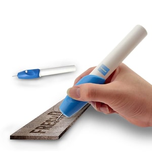 May include: An engraving tool with a blue grip and white body is shown in use, etching the word "FRESH" into a wooden surface. A second tool is visible in the background. The tool has a needle tip. The word "FRESH" is engraved.