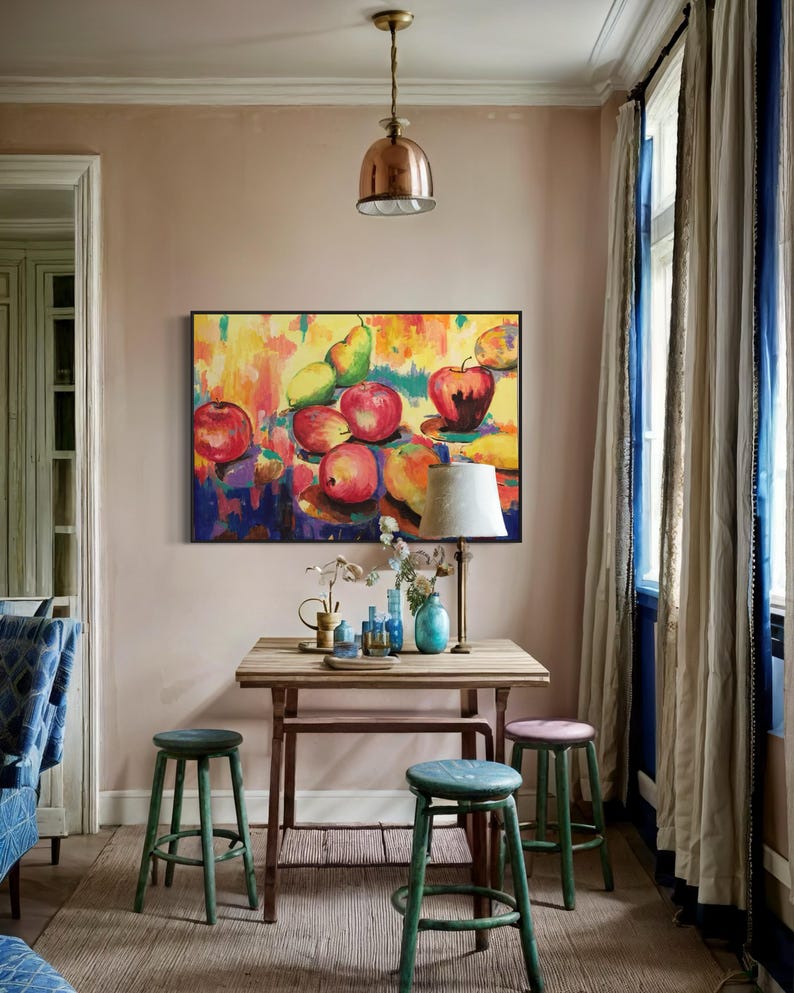 May include: A colorful still life painting of fruit, including apples, pears, and lemons, hanging on a wall in a room with a wooden table and green stools.