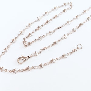 May include: A silver chain necklace with star-shaped links. The necklace is approximately 18 inches long and has a lobster claw clasp.