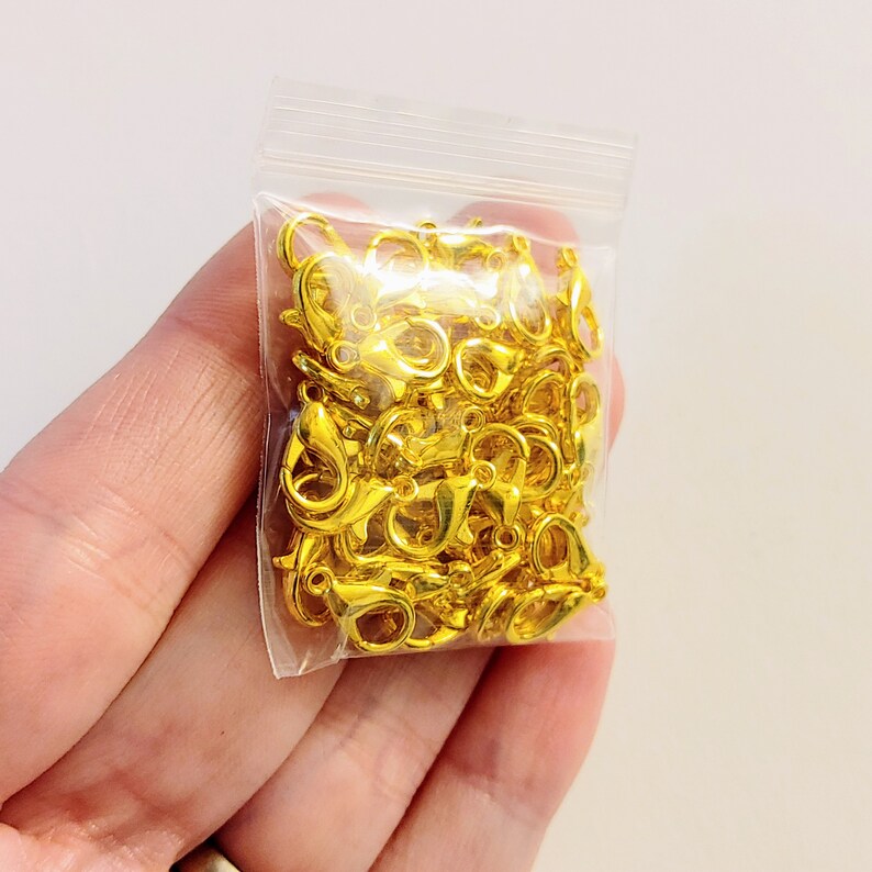 May include: A bag of gold-colored metal lobster clasps. The clasps are small and are perfect for jewelry making.
