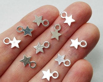 May include: Silver star charms with a jump ring. The charms are about 1 inch in size and have a shiny finish.
