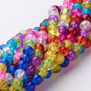 Pu&ograve; includere: Una collana di perline di vetro colorate con una finitura craquel&eacute;. Le perline sono rotonde e presentano una variet&agrave; di colori, tra cui blu, verde, giallo, arancione, rosso, rosa e viola.