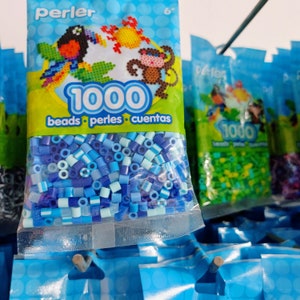 Puede incluir: Bolsas de cuentas Perler en varios tonos de azul. El embalaje presenta dise&ntilde;os de arte pixelado coloridos de un loro, un mono y otras formas. Cada bolsa contiene 1000 cuentas y lleva la marca Perler.