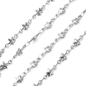 May include: Silver chain necklace with star-shaped links. The chain is made of metal and has a lobster clasp closure.