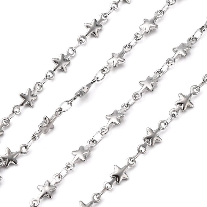 May include: Silver chain necklace with star-shaped links. The chain is made of metal and has a lobster clasp closure.