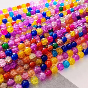 Pu&ograve; includere: Un filo di perline di vetro colorate con una superficie testurizzata macchiata. Le perline sono rotonde e sono disponibili in una variet&agrave; di colori, tra cui rosso, arancione, giallo, verde, blu, viola e rosa.