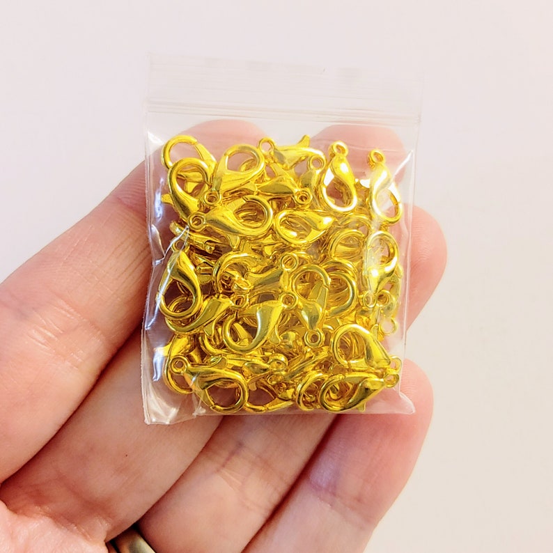 May include: A bag of gold-toned metal lobster clasps. The clasps are small and are perfect for jewelry making.
