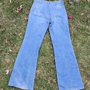 May include: A pair of light blue denim bell bottom pants with two large pockets on the back.