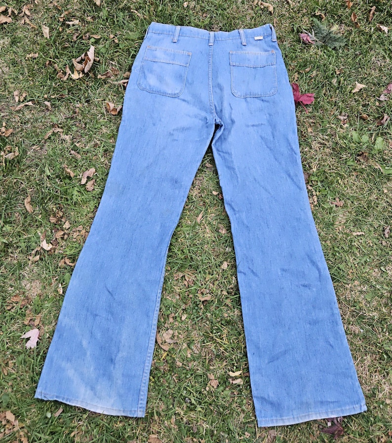 May include: A pair of light blue denim bell bottom pants with two large pockets on the back.