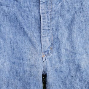 May include: A pair of light blue denim jeans with a brown button and a