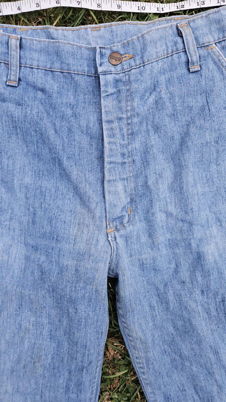 May include: A pair of light blue denim jeans with a brown button and a