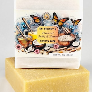 May include: A white bar of soap with a label that reads "Dr. Stamler's Oatmeal Milk & Honey Luxury Soap" and "Net wt. 4oz (113g)". The label features a colorful illustration of butterflies, honey, oats, and coconuts.
