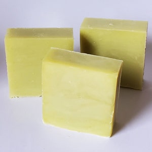 May include: Three bars of handmade soap, each a pale green color. The soap bars are rectangular and have a smooth, slightly textured surface.