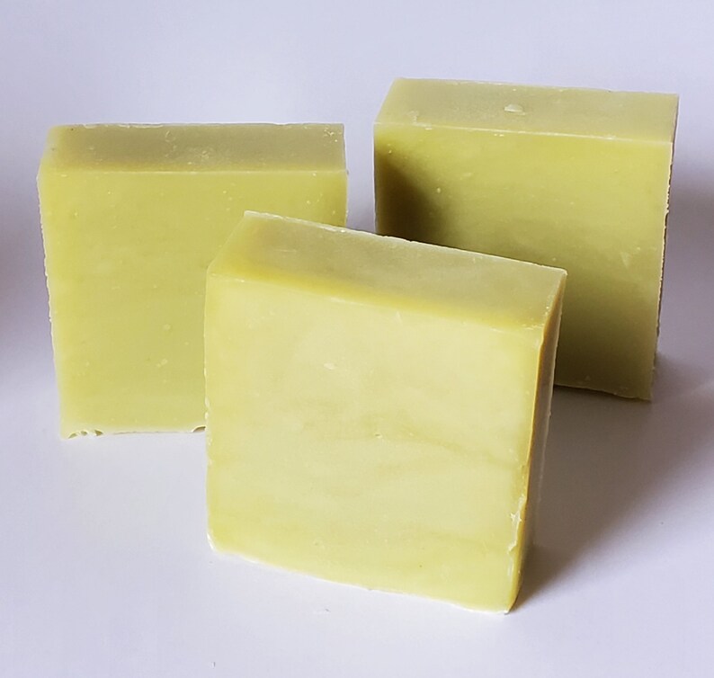May include: Three bars of handmade soap, each a pale green color. The soap bars are rectangular and have a smooth, slightly textured surface.