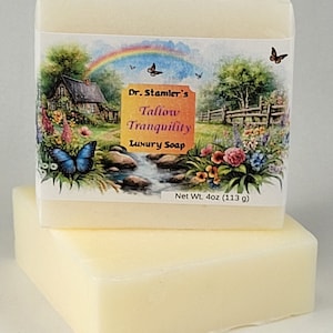 May include: A bar of Dr. Stamler's Tallow Tranquility Luxury Soap, with a net weight of 4 oz (113 g). The soap is wrapped in a white paper with a colorful image of a cottage, a rainbow, butterflies, and flowers.